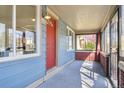 View of the enclosed front porch featuring a red door and ample sunlight at 3527 W 44Th Ave, Denver, CO 80211