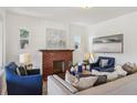 Cozy living room featuring a brick fireplace, neutral sofa, and bright white walls at 3527 W 44Th Ave, Denver, CO 80211