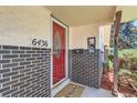 Inviting front entry featuring a red door, brick accents, and clear address numbers at 6436 Otis St, Arvada, CO 80003
