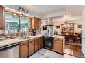 Functional kitchen features wooden cabinets, modern appliances, and a view into the dining room at 6436 Otis St, Arvada, CO 80003