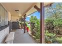 Covered porch with seating area, offering a welcoming outdoor space with greenery at 6436 Otis St, Arvada, CO 80003