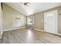 Open-concept living room with wood-look flooring, vaulted ceiling, and natural light from a window at 180 S Lamar St, Lakewood, CO 80226