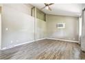 Bright living room featuring vaulted ceilings, wood-look flooring, and a ceiling fan at 180 S Lamar St, Lakewood, CO 80226