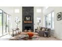 Inviting living room features a striking stone fireplace, bright windows and stylish decor at 8230 W Tennessee Ct, Lakewood, CO 80226