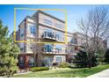 Multi-story condo building featuring balconies, manicured landscaping, and architectural details under a clear blue sky at 5677 S Park Pl # B310, Englewood, CO 80111