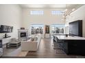 Open concept living room with hardwood floors, fireplace, and a modern kitchen with black cabinets at 5677 S Park Pl # B310, Englewood, CO 80111