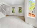 Bright and airy living room featuring neutral paint, large windows, and staircase at 6310 W Sumac Ave, Littleton, CO 80123
