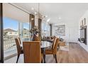 Bright dining area with wood floors, modern chandelier, and views of the outdoors at 940 Andrews Crest Dr, Berthoud, CO 80513