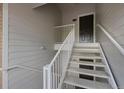 A well-lit condo building walkway with white rails lead to front doors at 15700 E Jamison Dr # 3-307, Englewood, CO 80112