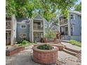 Inviting townhome community space with a brick planter, steps, and lush landscaping at 101 S Downing St # 8, Denver, CO 80209
