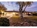 View of the home's exterior with driveway, large tree, and well-manicured lawn, set against a colorful sky at 8895 Morton Rd, Niwot, CO 80503
