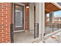 Inviting brick entryway with a modern front door, black railings, and a covered porch at 7870 W 43Rd Pl, Wheat Ridge, CO 80033