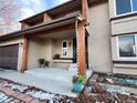 Inviting front porch with wood columns, black door, and potted flowers for added curb appeal at 18438 E Berry Dr, Centennial, CO 80015