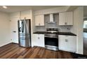 Modern kitchen features white cabinets, stainless steel appliances, and stylish black backsplash at 18438 E Berry Dr, Centennial, CO 80015