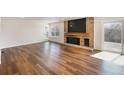 Bright living room with hardwood floors, brick fireplace and sliding glass doors to the deck at 18438 E Berry Dr, Centennial, CO 80015