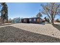 Charming home with a gravel front yard, dark gray exterior, and a sidewalk leading to the entrance at 1285 Roslyn St, Denver, CO 80220