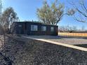 Beautifully renovated home with dark gray siding, rock landscaping, black mulch, and a sidewalk at 1285 Roslyn St, Denver, CO 80220