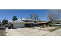 Spacious home with a large driveway and two-car garage, set against a blue sky at 8389 Benton Way, Arvada, CO 80003