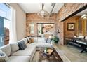 Bright living room with brick accent wall, comfortable sectional sofa, and an open view to the dining space at 2500 Walnut St # 201, Denver, CO 80205