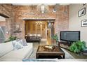 Cozy living room features exposed brick, comfortable seating, and an inviting, open layout to dining space at 2500 Walnut St # 201, Denver, CO 80205