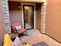 Relaxing outdoor patio with comfortable seating, showing the home's inviting entrance through a glass storm door at 9238 Viaggio Way, Highlands Ranch, CO 80126