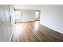 Spacious living room with beautiful hardwood flooring and natural light streaming in through large windows at 437 S Fetzer St, Byers, CO 80103