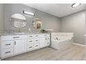 Bright bathroom with dual round mirrors, quartz counters and a tile-surround soaking tub at 10183 Grove Loop # D, Westminster, CO 80031