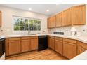 Traditional kitchen features light wood cabinets, tile countertops, and a window providing plenty of natural light at 10183 Grove Loop # D, Westminster, CO 80031