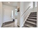 Bright entryway with hardwood floors, a staircase, and a view into the living area at 296 N Newcastle Way, Aurora, CO 80018