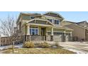 Charming two-story home with a three-car garage, stone accents, and inviting front porch at 296 N Newcastle Way, Aurora, CO 80018
