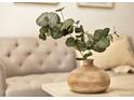 Close-up of living room decor highlighting a modern vase, lush greenery, and a comfortable sofa at 1629 N Clarkson St # 23, Denver, CO 80218