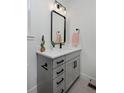 Stylish bathroom vanity with gray cabinets, modern hardware, quartz countertop, and black framed mirror at 10866 Lyric St, Lone Tree, CO 80134