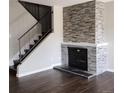 Close-up of the living room's fireplace with stone surround and wood floors at 9017 E Oxford Dr, Denver, CO 80237