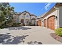 This home features a large concrete driveway and garage with paneled doors at 1287 Buffalo Ridge Rd, Castle Pines, CO 80108