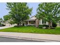 Charming home featuring a well-manicured lawn, mature trees, and a welcoming front porch at 3144 Stevens N Cir, Erie, CO 80516