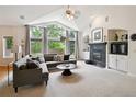 Bright living room featuring vaulted ceilings, large windows, and a cozy fireplace creating an inviting atmosphere at 3144 Stevens N Cir, Erie, CO 80516