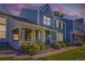 Inviting home with covered porch, lush greenery, and a charming facade under a beautiful sky at 19725 Rosewood Ct, Parker, CO 80138