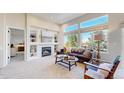 Bright living room with large windows, cozy fireplace, built-in shelving, and comfortable furnishings at 6226 Quartz Loop, Arvada, CO 80403