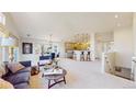Open-concept living space flows into the kitchen, with modern lighting, plush seating, and bright natural light at 6226 Quartz Loop, Arvada, CO 80403