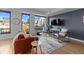Bright living room showcasing stylish seating, a modern rug, and large windows with cityscape views at 1750 Wewatta St # 830, Denver, CO 80202