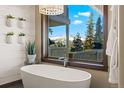 Luxurious bathroom with modern tub, chandelier, and scenic mountain view at 85 Uncle Sam Lode, Breckenridge, CO 80424