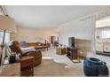 Cozy living room with patterned wallpaper, comfortable seating, and a view into an adjacent dining area at 10475 Tancred St, Northglenn, CO 80234