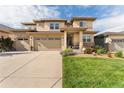 Attractive two-story home with a three-car garage, manicured lawn, and colorful flowerbeds enhancing the curb appeal at 19429 W 88Th Dr, Arvada, CO 80007