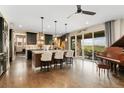 Open kitchen with a large island, seating, stainless steel appliances, hardwood floors, and access to the outdoor patio at 19429 W 88Th Dr, Arvada, CO 80007