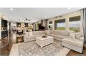 Open-concept living room with large windows offering views of the plains and a neutral colored couch at 19429 W 88Th Dr, Arvada, CO 80007