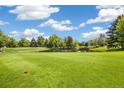 Picturesque golf course featuring a pond, mature trees, green grass, and blue skies at 3082 S Wheeling Way # 202, Aurora, CO 80014