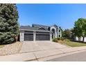 Charming two-story home with a three car garage, landscaped yard, and a modern exterior design at 9382 Lark Sparrow Dr, Highlands Ranch, CO 80126