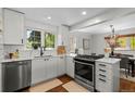 Bright, remodeled kitchen featuring white cabinets, stainless steel appliances and hardwood floors at 400 Holly St, Denver, CO 80220
