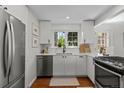 Bright kitchen featuring white cabinets, stainless steel appliances, and large windows at 400 Holly St, Denver, CO 80220