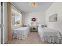 Cozy bedroom with two twin beds, natural light streaming in from a window, and simple, tasteful decor at 4830 Monarch Dr, Firestone, CO 80504